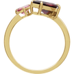 Gold ring with red and pink gemstones on a white background