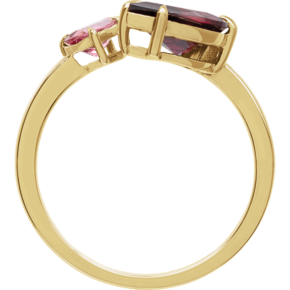 Gold ring with red and pink gemstones on a white background