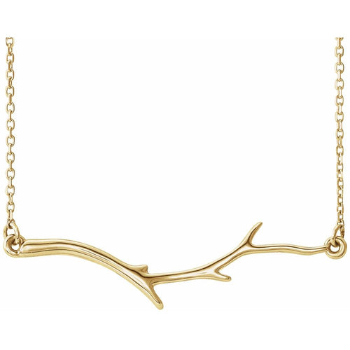 Gold branch-shaped necklace on a white background